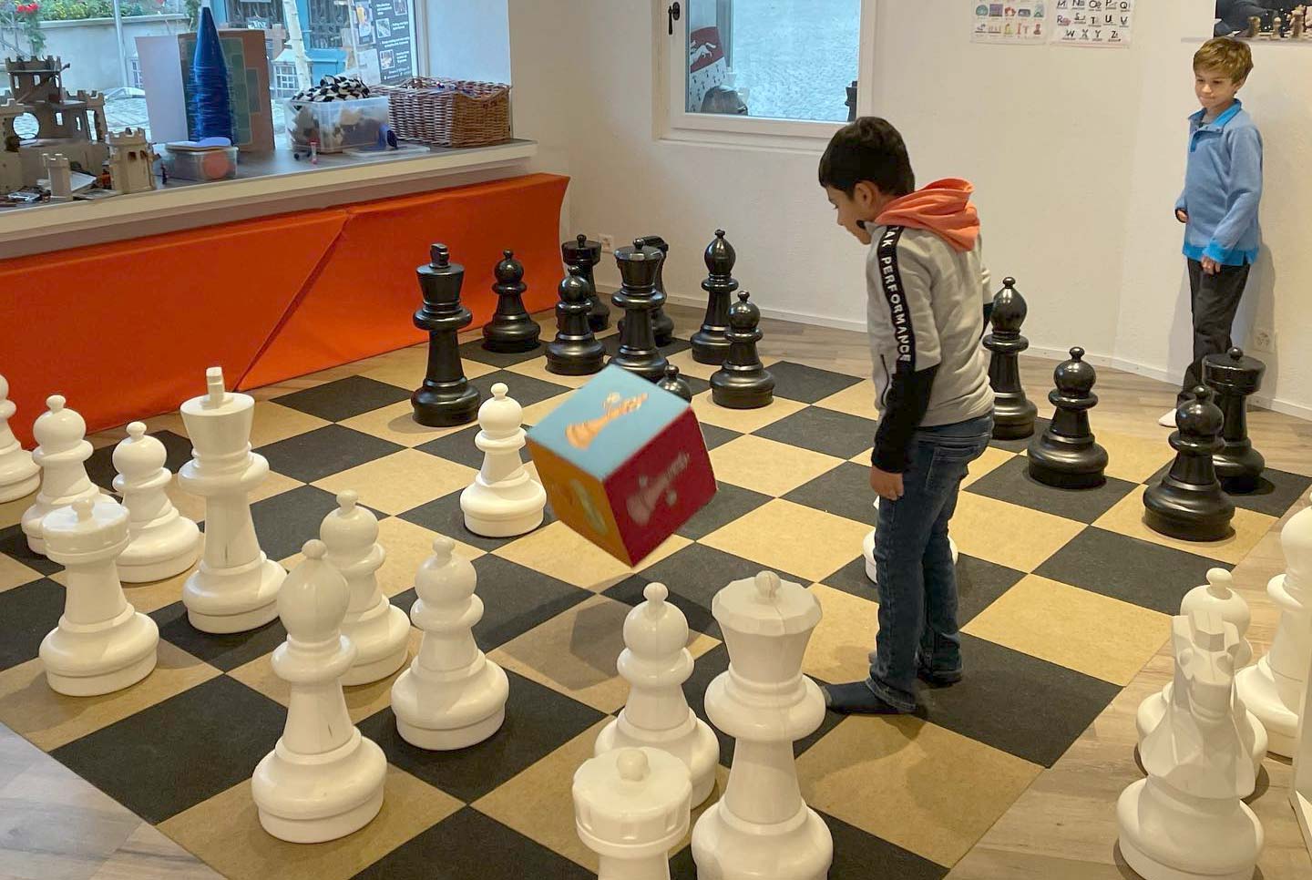 Kids playing chess with a dice